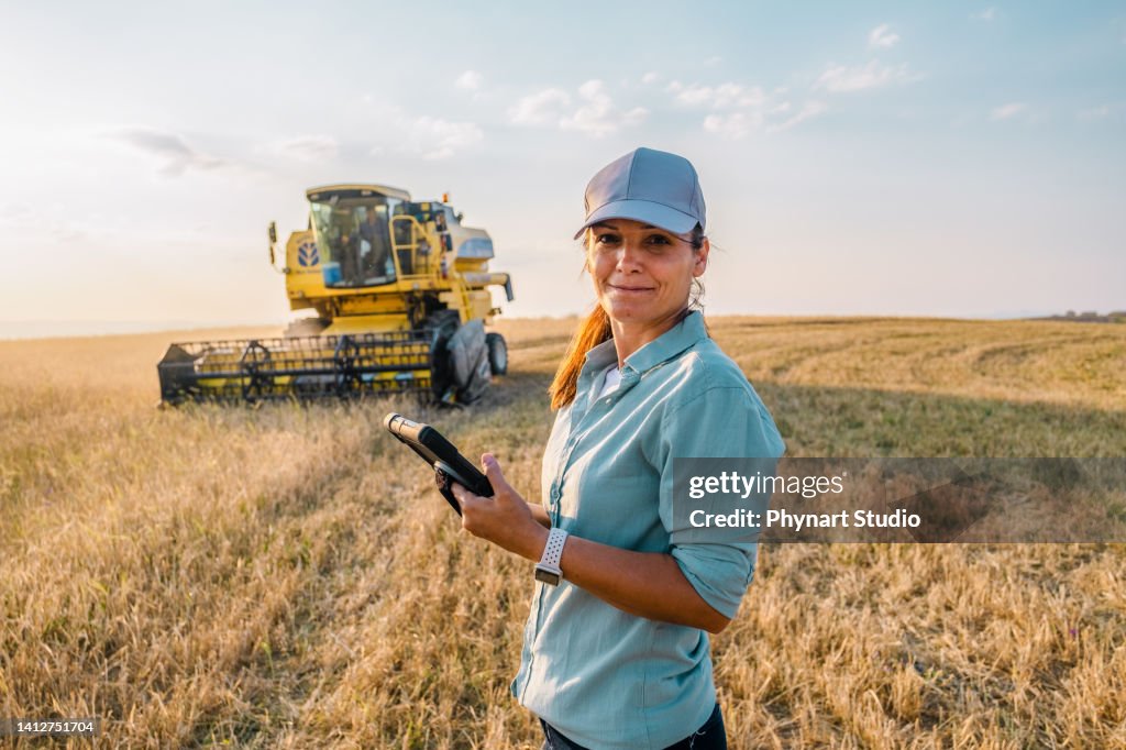 Female Farmer is Holding a Digital Tablet in a Farm Field. Smart Farming