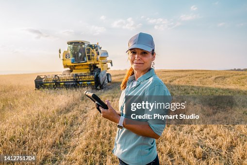 Female Farmer is Holding a Digital Tablet in a Farm Field. Smart Farming Female Farmer is Holding a Digital Tablet in a Farm Field. Smart Farming