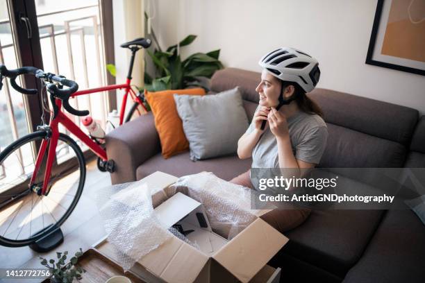 woman receiving new bike helmet on delivery. - sportswear retail stock pictures, royalty-free photos & images