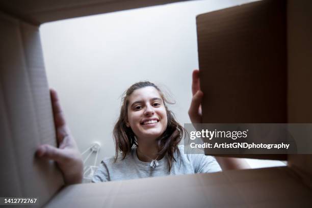 smiling woman opening a carton box. - openingsevenement stockfoto's en -beelden
