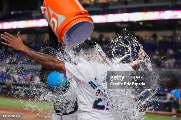 Pablo Lopez of the Miami Marlins throws water on Sandy Alcantara after he pitched a complete game against the Cincinnati Reds at loanDepot park on...