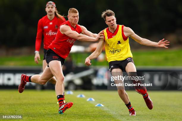 Jordan Ridley of the Bombers kicks the ball under pressure from Peter Wright of the Bombers during an Essendon Bombers AFL training session at The...