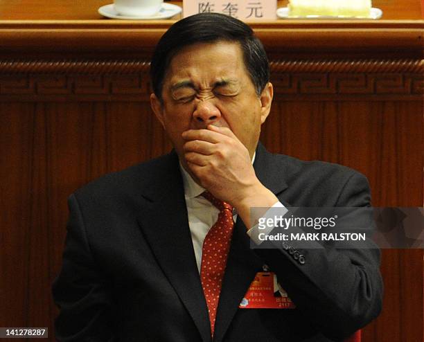 Chongqing Party Secretary Bo Xilai yawns during the closing ceremony of the National People's Congress at the Great Hall of the People in Beijing on...