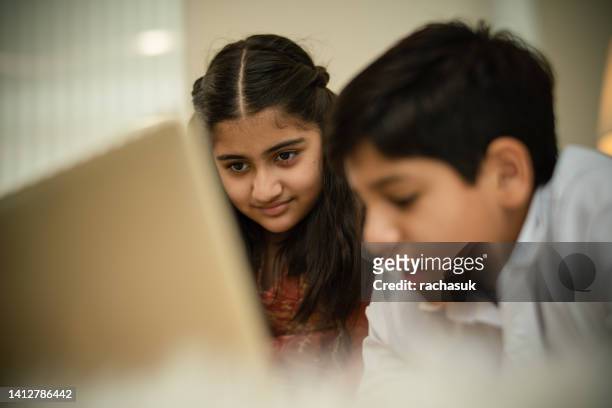 young indian girl reading a book - 7 stockfoto's en -beelden