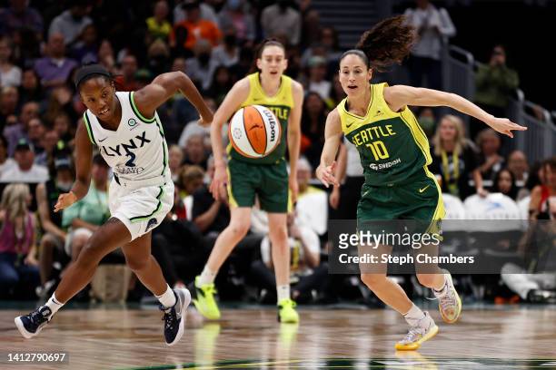 Evina Westbrook of the Minnesota Lynx and Sue Bird of the Seattle Storm chase a loose ball during the third quarter at Climate Pledge Arena on August...