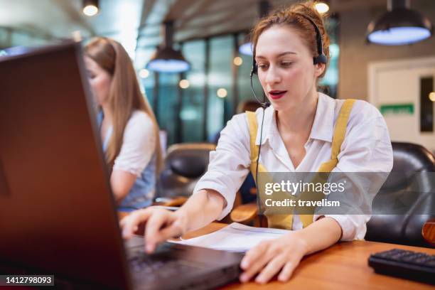 using customer service solution to improve a product, service and business process. female call center talking with customer on voice call for product support in a tech business office - back office stock pictures, royalty-free photos & images