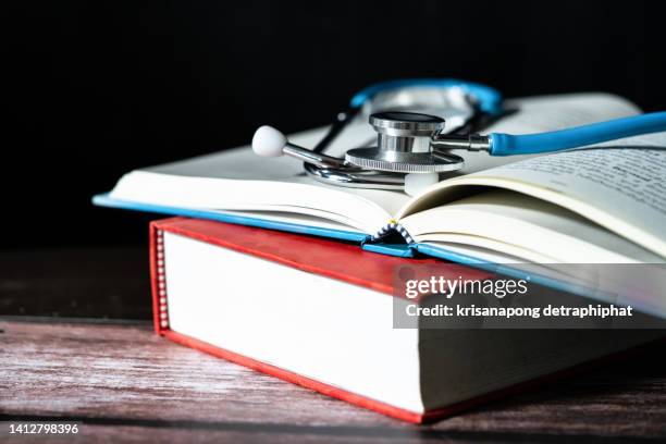 medical stethoscope with books - scientific literature stock-fotos und bilder