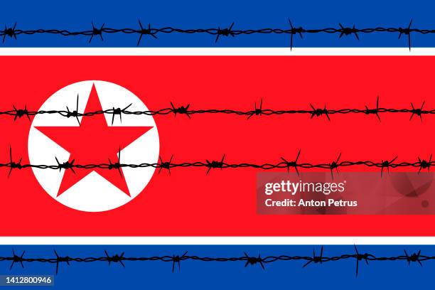 barbed wire on the background of the north korean flag - north korea stock pictures, royalty-free photos & images