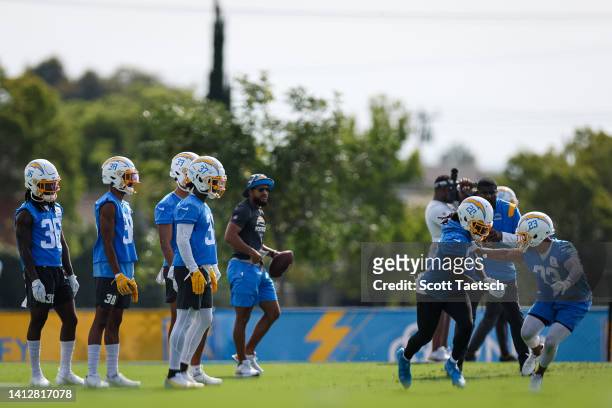 Tevaughn Campbell and Bryce Callahan of the Los Angeles Chargers participate in a drill with teammates during training camp at Jack Hammett Sports...