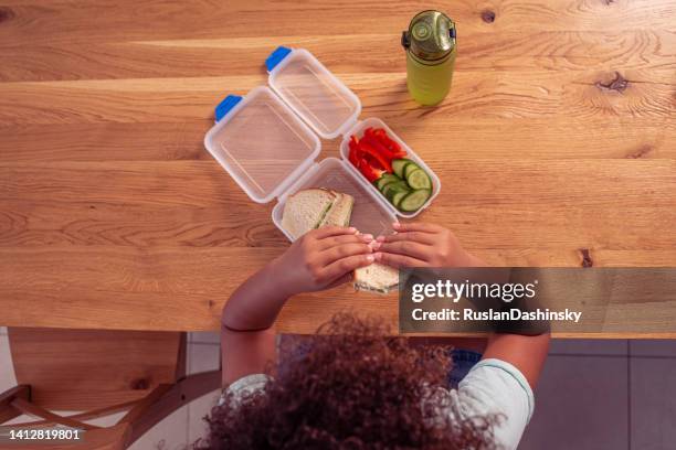 immagine dall'alto di una bambina studentessa che mangia un pranzo sano a scuola. - pausa pranzo foto e immagini stock