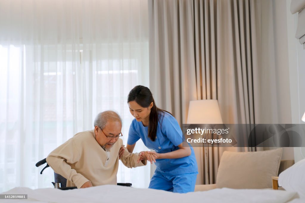 Nurse take care senior man in the bedroom.