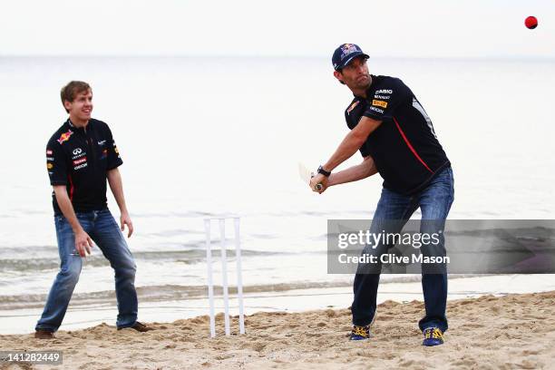 Sebastian Vettel of Germany and Red Bull Racing and Mark Webber of Australia and Red Bull Racing try their hand at beach cricket on St Kilda Beach...