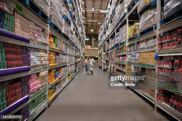 couple pushing a trolley down a supermarket aisle - huge task stock pictures, royalty-free photos & images