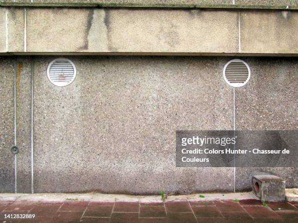concrete facade with ventilation grilles and paved sidewalk in brussels, belgium - lawn aeration stock pictures, royalty-free photos & images