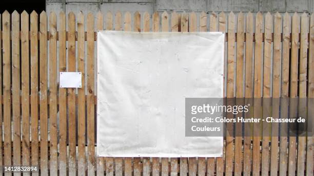 an empty white plastic tarpaulin on the palisade of a construction site in brussels, belgium - tarpaulin 個照片及圖片檔