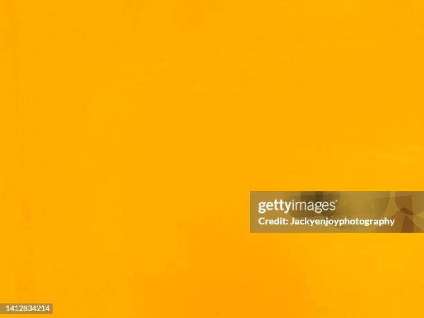 orange yellow coloured grunge textured empty and blank wall backgrounds - texture jaune photos et images de collection