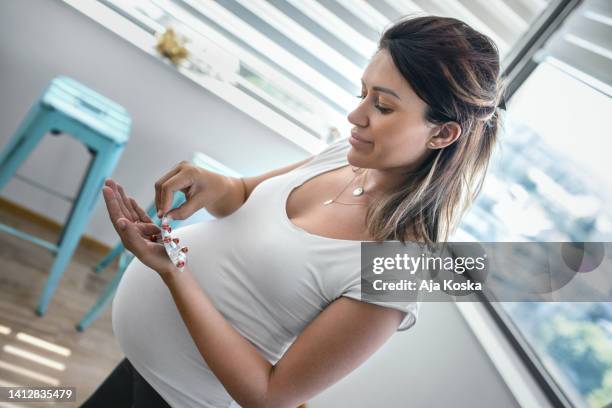 pregnant woman taking pill at home. - morning sickness 個照片及圖片檔