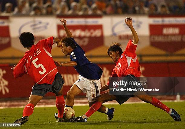 Daisuke Matsui of Japan competes for the ball with Cho Sung-Hwan and Kim Dong-Jin of South Korea during the international friendly match between...