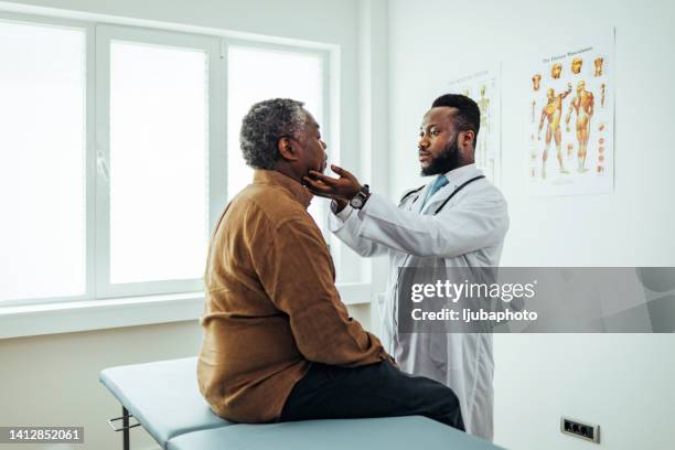 médico masculino palpando a pacientes ganglios linfáticos submandibulares - throat photos fotografías e imágenes de stock