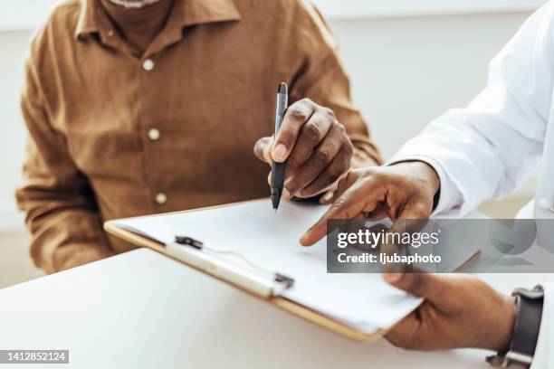man having a visit at male doctor's office - preencher um formulário imagens e fotografias de stock
