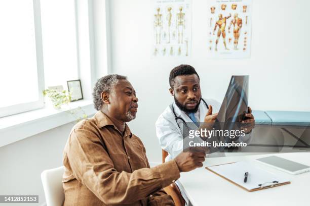 man and radiologist looking at clear lung x-ray - human spine stock pictures, royalty-free photos & images