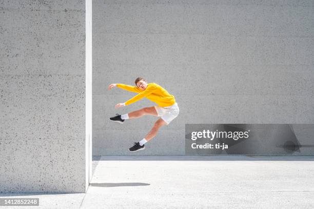 young male dancer posing outdoors - man jump outdoor young city stock pictures, royalty-free photos & images