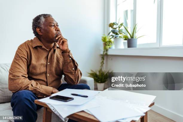 mature businessman looking out of window - paperwork frustration stock pictures, royalty-free photos & images