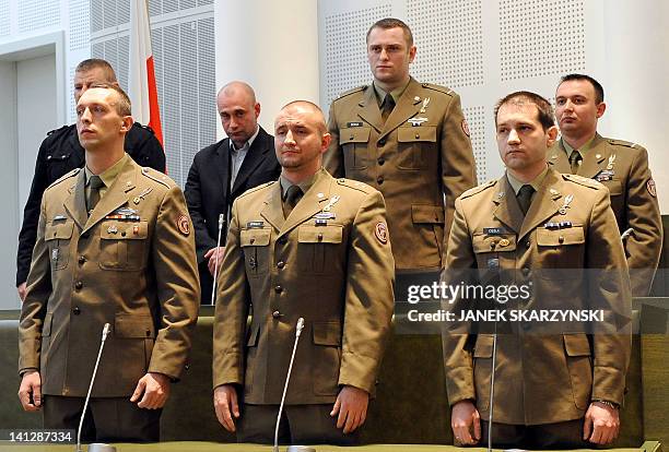 Polish soldiers stand in court as they listen to judge Wieslaw Blus who overturned the acquittal on four of the seven troops charged with having...