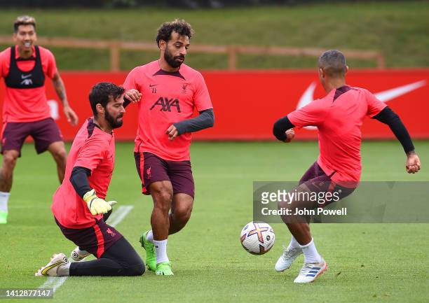 Thiago Alcantara, Mohamed Salah and Alisson Becker of Liverpool during a training session at AXA Training Centre on August 04, 2022 in Kirkby,...