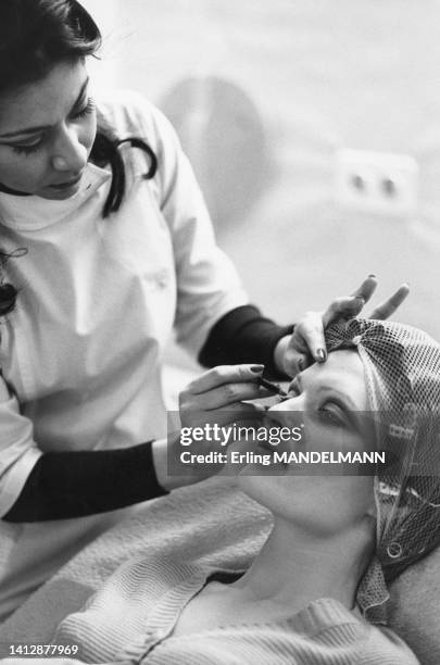 Une jeune femme est maquillée par une esthéticienne dans les années 1980.