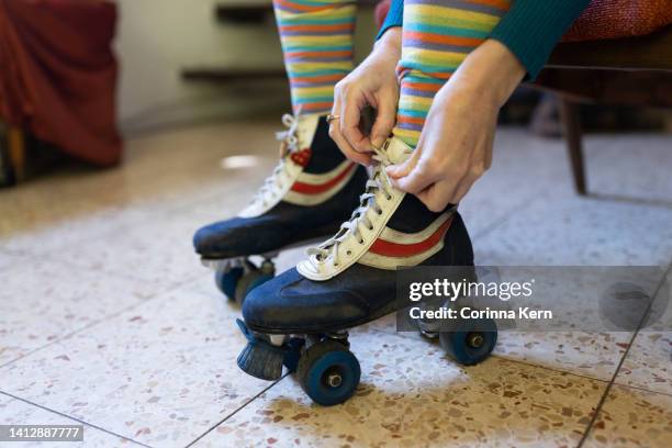 woman's hands tying shoelaces of roller skates - figure skating photos photos et images de collection