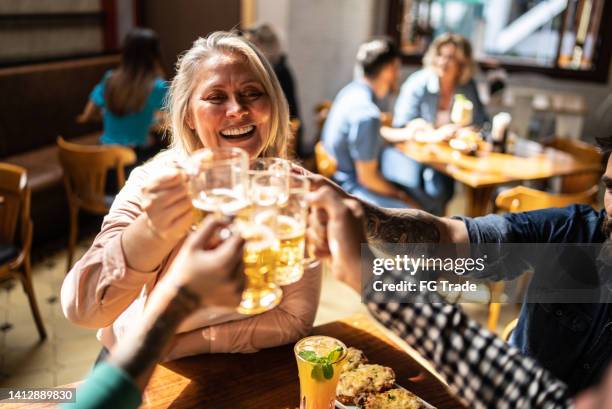 friends talking and toasting a beer  at a bar - pub food stock pictures, royalty-free photos & images