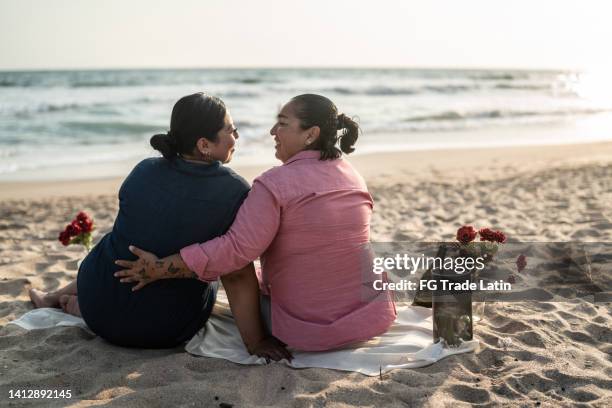 lesbian couple on a romantic date on the beach - lesbian date stock pictures, royalty-free photos & images