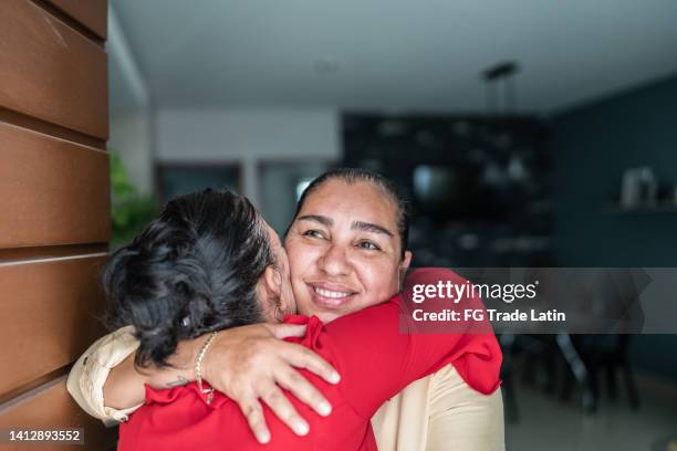 daughter opening front door to mother enter at home - family smiling at front door stock pictures, royalty-free photos & images