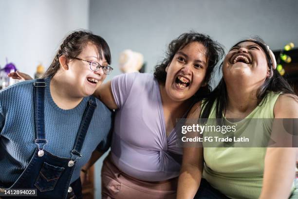 disabled young friends embracing in the bedroom at home - mental disability stock pictures, royalty-free photos & images