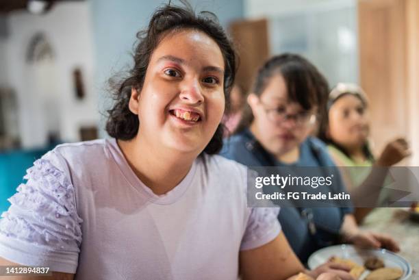 portrait of psychomotor retardation young woman with disabled friends in the kitchen counter at home - autistic adult imagens e fotografias de stock