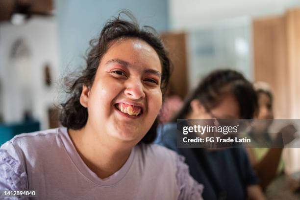 portrait of psychomotor retardation young woman with disabled friends at home - teenager cerebral palsy stock pictures, royalty-free photos & images