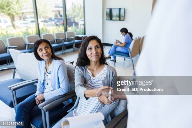 mother watches as daughter shakes hands with er doctor - spoedeisende geneeskunde stockfoto's en -beelden