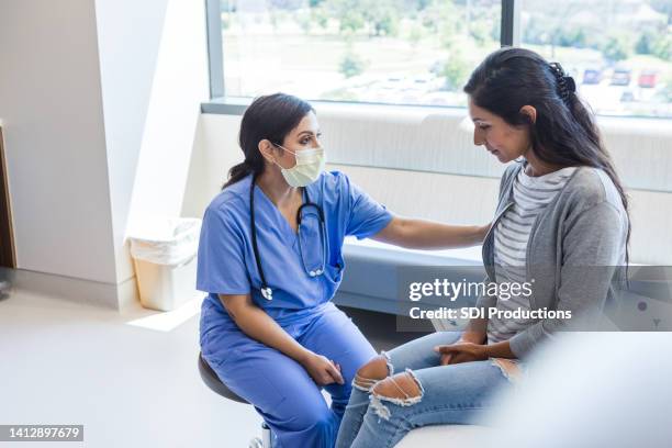 ärztin tröstet trauernde patientin - triage stock-fotos und bilder