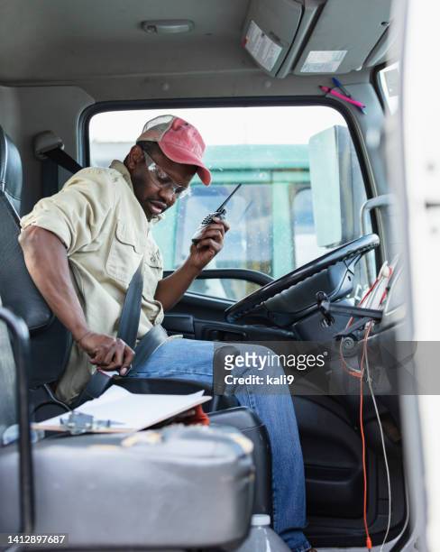 african-american truck driver fastening seat belt - trucker hat stock pictures, royalty-free photos & images