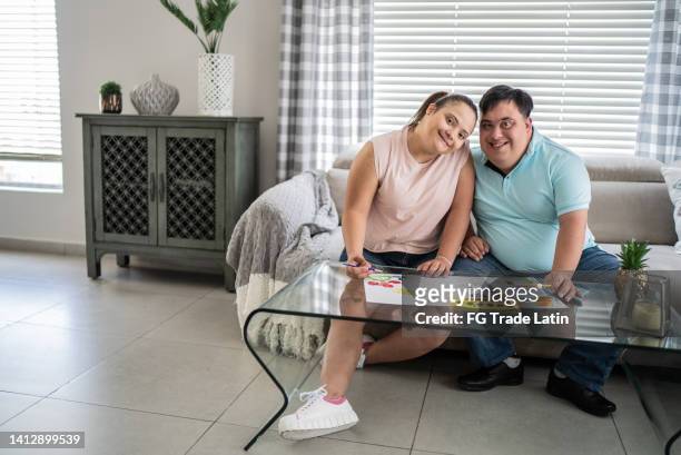 portrait of a couple with special needs painting at home - house for an art lover stock pictures, royalty-free photos & images