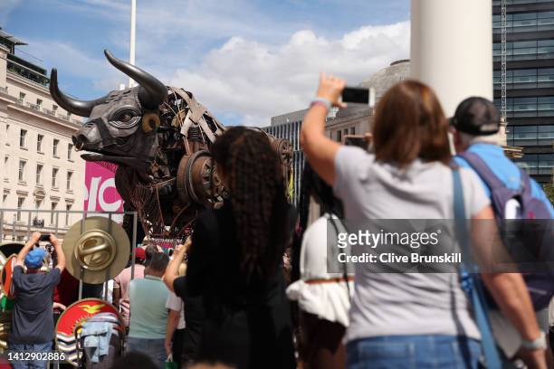 Spectators take photos of the giant mechanical bull on day seven of the Birmingham 2022 Commonwealth Games at Centenary Square on August 04, 2022 on...