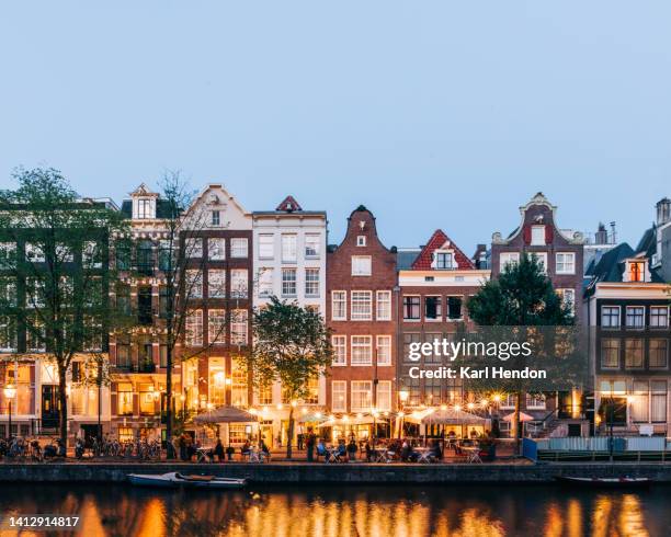 a dusk view of a restaurant and street in amsterdam, the netherlands - waterfront dining stock pictures, royalty-free photos & images