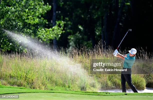 Trent Phillips of the United States plays his second shot of the 15th hole during the first round of the Wyndham Championship at Sedgefield Country...