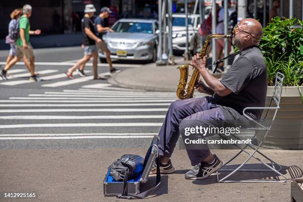 man playing a saxophone in the street - street artist stock pictures, royalty-free photos & images