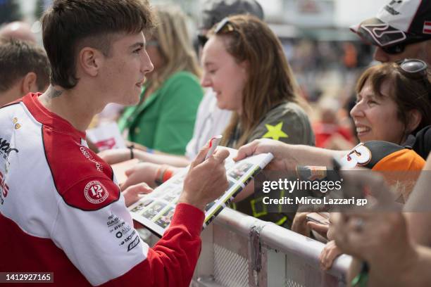 Izan Guevara of Spain and GASGAS Aspar signs autographs for fans during the pre-event "Day of Champions" during the MotoGP of Great Britain -...