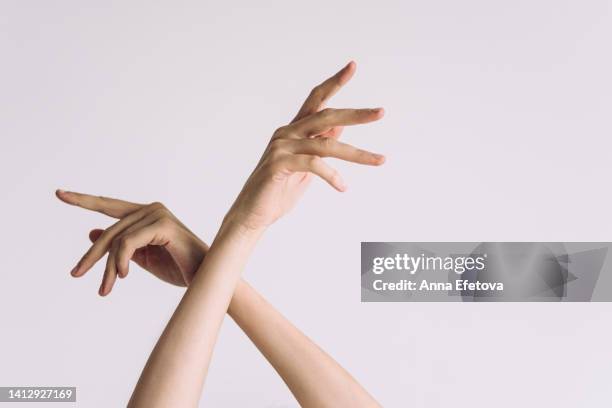 aesthetic woman hands against white background. she has no polish on her nails. concept of natural beauty - fingernail stock photos et images de collection