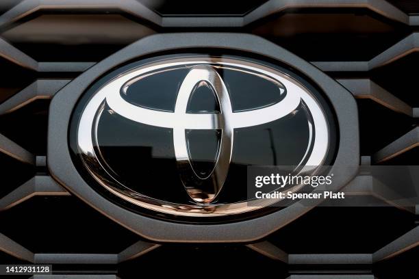 The front emblem on the grille of a Toyota is displayed in the window at Bay Ridge Toyota car dealership in Brooklyn on August 04, 2022 in New York...