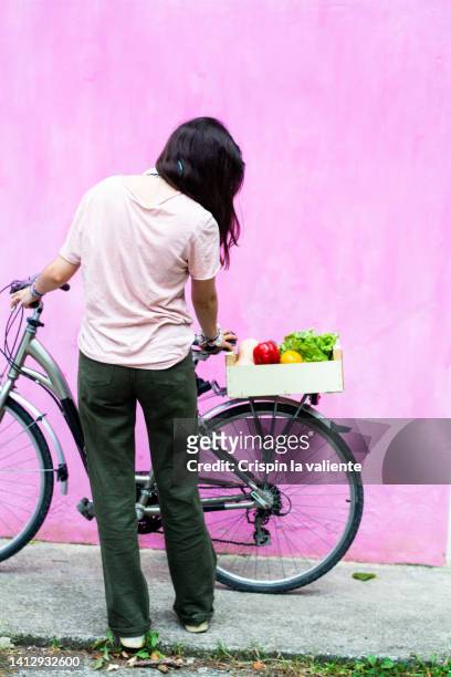 back view student with bicycle with a box of vegetables - shopping with bike stock-fotos und bilder