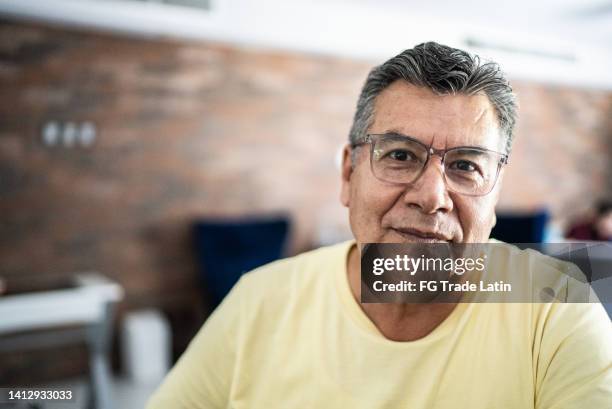 porträt des reifen mannes zu hause - lateinamerikanische abstammung stock-fotos und bilder